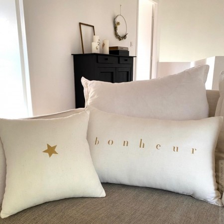 Square old white linen cushion with a gold star